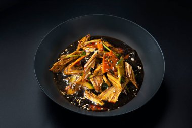 Siyah arka planda kuşkonmaz olan Asya salatası.