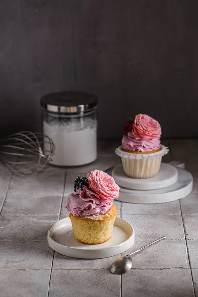 Cupcakes mit rosa Buttercreme und Rose Stockbild