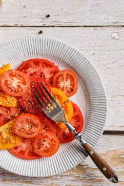 Domatesler açık arkaplanda sarı ve kırmızıdır. Yüksek kalite fotoğraf