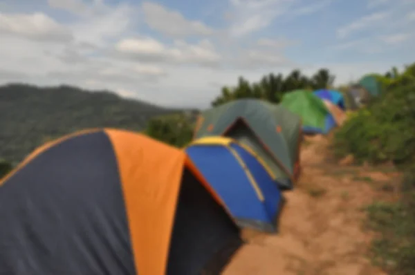 Many people pitch tents in mountain attractions during the extended holiday season - blur images for background
