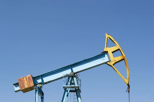 Blue pumpjack on blue sky — Stock Photo, Image