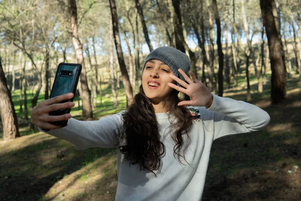 Mujer joven hablando por teléfono en el bosque — Foto de Stock