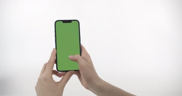 Yeşil Ekranlı Akıllı Telefonu Tutan Yukarı Kaydıran Kadın Beyaz Arkaplanda — Stok video