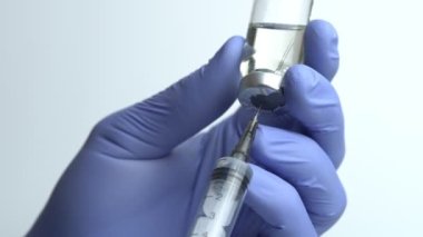 Doktor 'un Mavi Eldivenli Elleri Şırıngayı Cam Şişesinden Sıvı İlaçla Doldurun