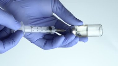  Close-up of Doctor's Hands in Blue Medical Gloves Filling Syringe with Liquid Medication from Glass Vial. Vertical video, 4k
