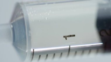 Aşırı Yakın plan İlaç Sıvısı Beyaz Arkaplanda Şırıngaya Dökülüyor. İğneler ve aşılar, 4k