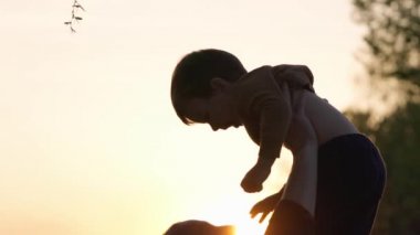 Genç adam gün batımında çocuğu kaldırır ve başının üstünde tutar. Ağır çekim. Baba ve Oğul gülümsüyor ve dışarıda eğleniyorlar.