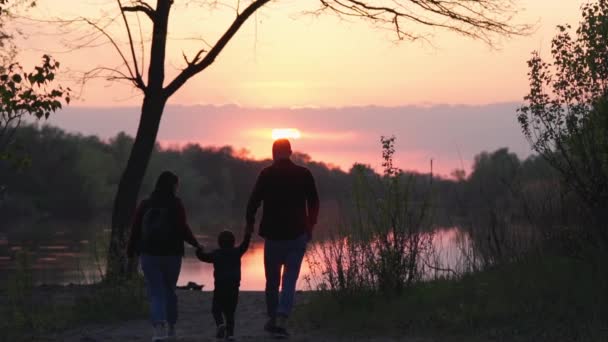 Parents Hold Child Hands Walk Banks River Background Beautiful Sunset — Stockvideo
