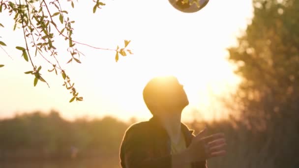 Młody Człowiek Rzuca Kopie Piłkę Głowę Tle Zachodu Słońca Powolny — Wideo stockowe