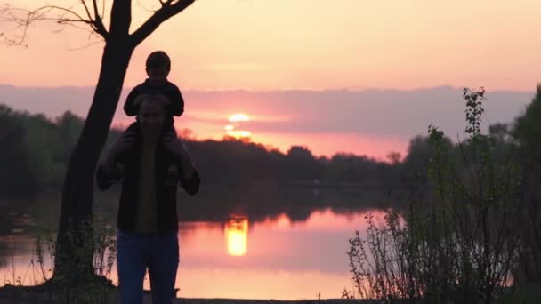 Silhouette Man Little Baby Shoulders Walking Background Colourful Sunset Slow — Stockvideo