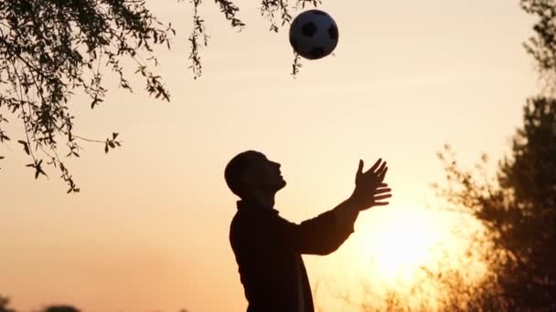 Silhouette Man Throws Kicks Ball His Head Sunset Background Slow — Vídeo de Stock