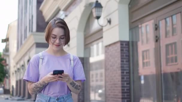 Junges Hübsches Mädchen Läuft Mit Handy Und Tippnachricht Die Straße — Stockvideo