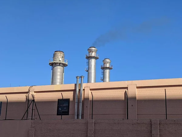 Power plant chimney with diesel generator in the city of Ceuta emitting black smoke, outdoors