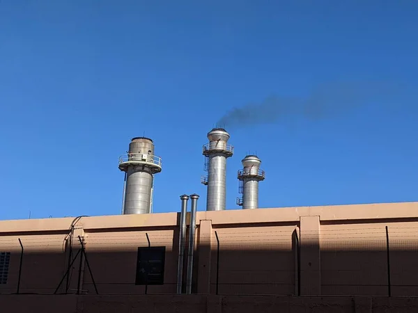 Power plant chimney with diesel generator in the city of Ceuta emitting black smoke, outdoors