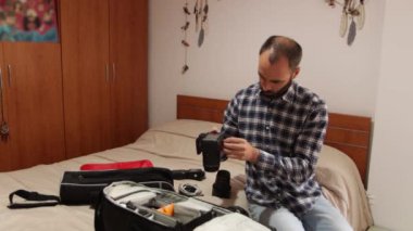 Fotoğraf taşımak için fotoğraf ekipmanlarını sırt çantasında saklıyorlar. 4k video. Evde..