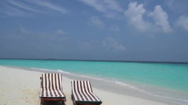 A close-up of sunbeds set on a beautiful tropical beach. Impressive image for every use.
