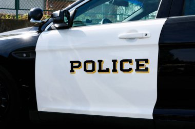 Kolluk kuvvetleri aracının beyaz kapısında polis işareti var. Kapat..