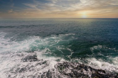 Kayalık sahilden Pasifik Okyanusu 'nda gün batımı ya da gün doğumu