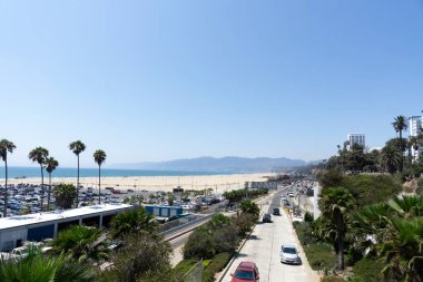 Santa Monica, ABD - 10 Ağustos 2021: Santa Monica Sahnesi. Kumsal, dağlar ve ağaçlar boyunca otoyol
