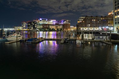 Boston Limanı güvertesinden gece binaların ışıklarının görüntüsü. Suyun üzerinde ufuk.