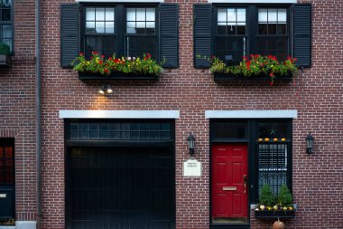 Bir apartman girişinin görüntüsü. Pencereli kırmızı kapı