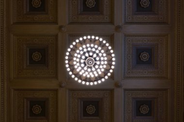 Tavana güzel bir avize ve oymalı bir tavanla bakıyorum.