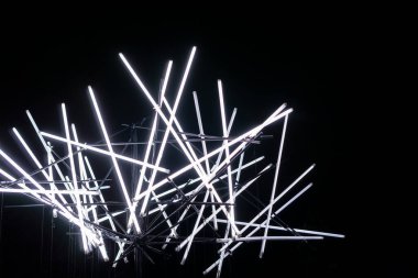 Siyah arka planda beyaz parlak çubuklar. Kaotik desenli uzun floresan lambaları