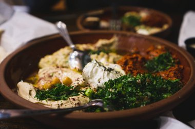 Humus, baba ghanoush, tabbouleh, salata gibi çeşitli Orta Doğu yemekleri. Paslı tabaklarda Doğu mezeleri