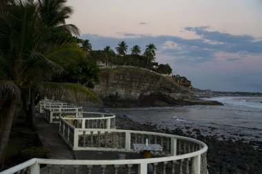 El Salvador, El Tunco 'da doğal kayalık sahili ve palmiye ağaçları olan uçurum manzarası. Gün batımında ya da gündoğumunda sahilde taşlar ve kayalar