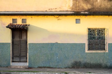 El Salvador 'da eski yıpranmış duvarı olan klasik bir ön kapı ve pencere. Eski bir binanın cephesi