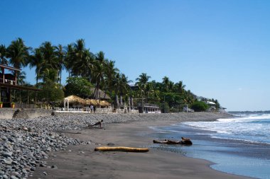 El Salvador, El Tunco 'daki turistik köye bakın. Pasifik Okyanusu kıyısında kulübeler ve palmiye ağaçları