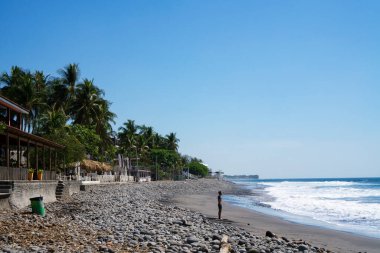 El Salvador, El Tunco 'daki turistik köye bakın. Pasifik Okyanusu kıyısında kulübeler ve palmiye ağaçları