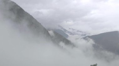 Bulutlar ve yağmur yabanda yürürken tüm manzarayı kaplıyor. Yükselen bulutlarla dağlarda hızlı değişen hava