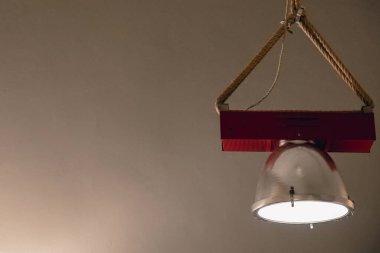 Duvara karşı tavandan asılı duran lamba. Metin için alanı kopyala