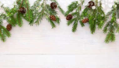 Beyaz ahşap arka planda ladin dalları ve koniler. Metnin için boşluklu Noel düzeni. 