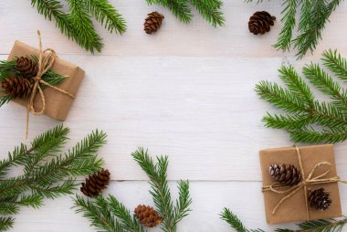 Spruce dalları, koniler, hediyeler, beyaz ahşap arka planda, metin için boşluğu olan bir Noel düzeni.. 