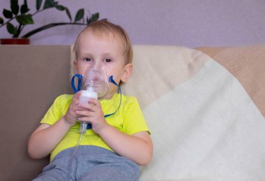 Bebek kanepede oturuyor, nebulizörle tedavi ediliyor, çocuk solunum yapıyor, evde tedavi oluyor..
