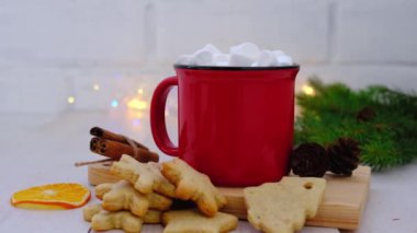 Kırmızı bardak kakao, zencefilli bisküvi ve arka planda çelenkler. Noel ve Yeni Yıl kavramı. 