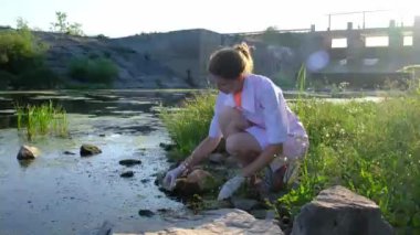 a laboratory assistant takes water samples from the reservoir