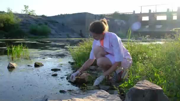A laboratory assistant takes water samples from the reservoir — стоковое видео