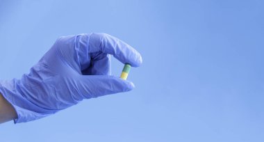 Bir doktor elinde tıbbi eldiven ile bir hap tutar, mesaj atmak için yeri olan bir düzendir.