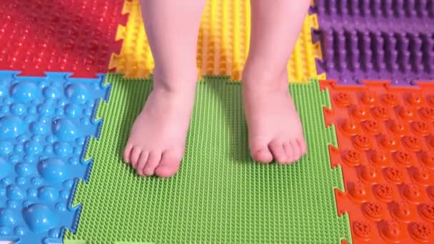 Das Kind macht Übungen auf der orthopädischen Matte, Beine aus nächster Nähe. — Stockvideo