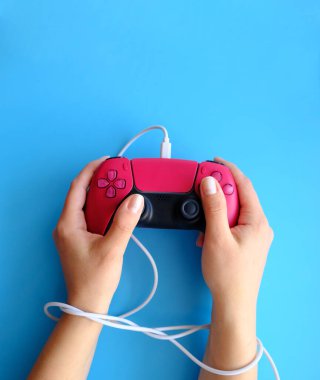 Gamepad 'den gelen bir kabloyla bağlanmış eller, kopyalanmış alan düzeni, video oyunlarına bağımlılık kavramı