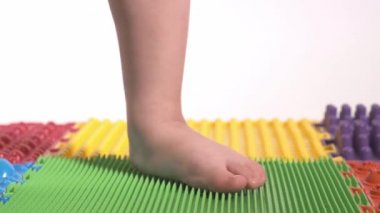 Çocuk ortopedi minderi üzerinde egzersiz yapıyor, bacakları yakın plan..