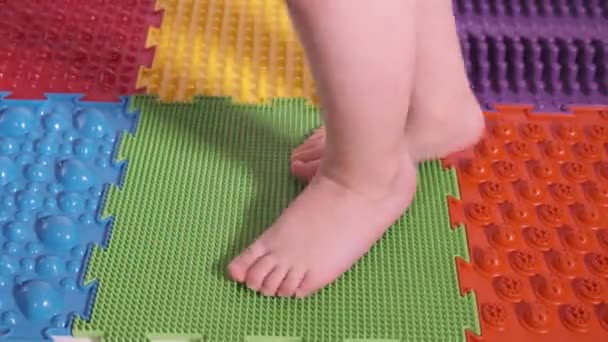 Das Kind macht Übungen auf der orthopädischen Matte, Beine aus nächster Nähe. — Stockvideo
