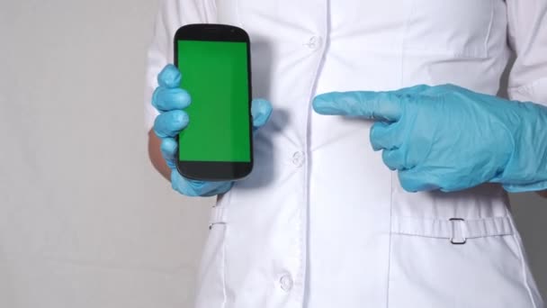 Arzt zeigt mit Handy und grünem Bildschirm auf die Hand — Stockvideo