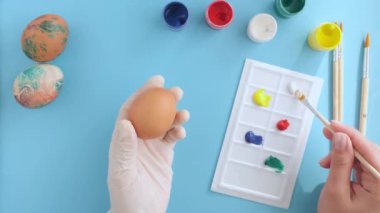Paskalya hazırlıkları, kadınların elleri yumurtaları boyar, yukarıdan yakın çekim görüntüsü