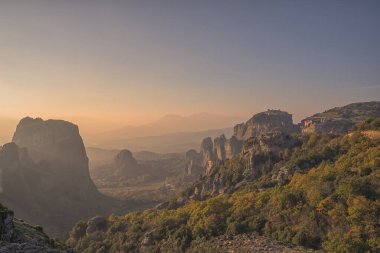 Yunanistan 'ın alacakaranlığında Meteora' daki kaya oluşumlarına bakıyorum.