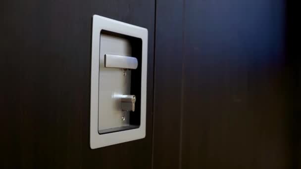Menangani logam abu-abu dengan kunci pada pintu kayu — Stok Video