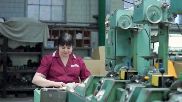 Работница текстильной фабрики складывает катушки ниток в коробки, упаковывает продукты — стоковое видео